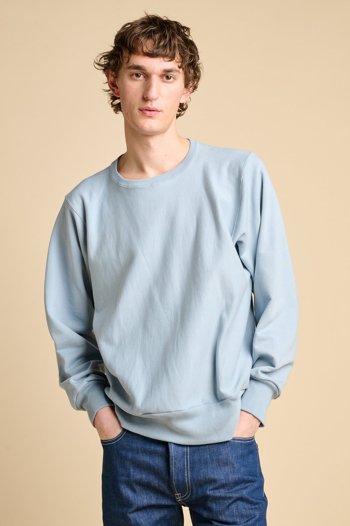 Man wearing sky blue oversized crew neck sweatshirt with jeans. 