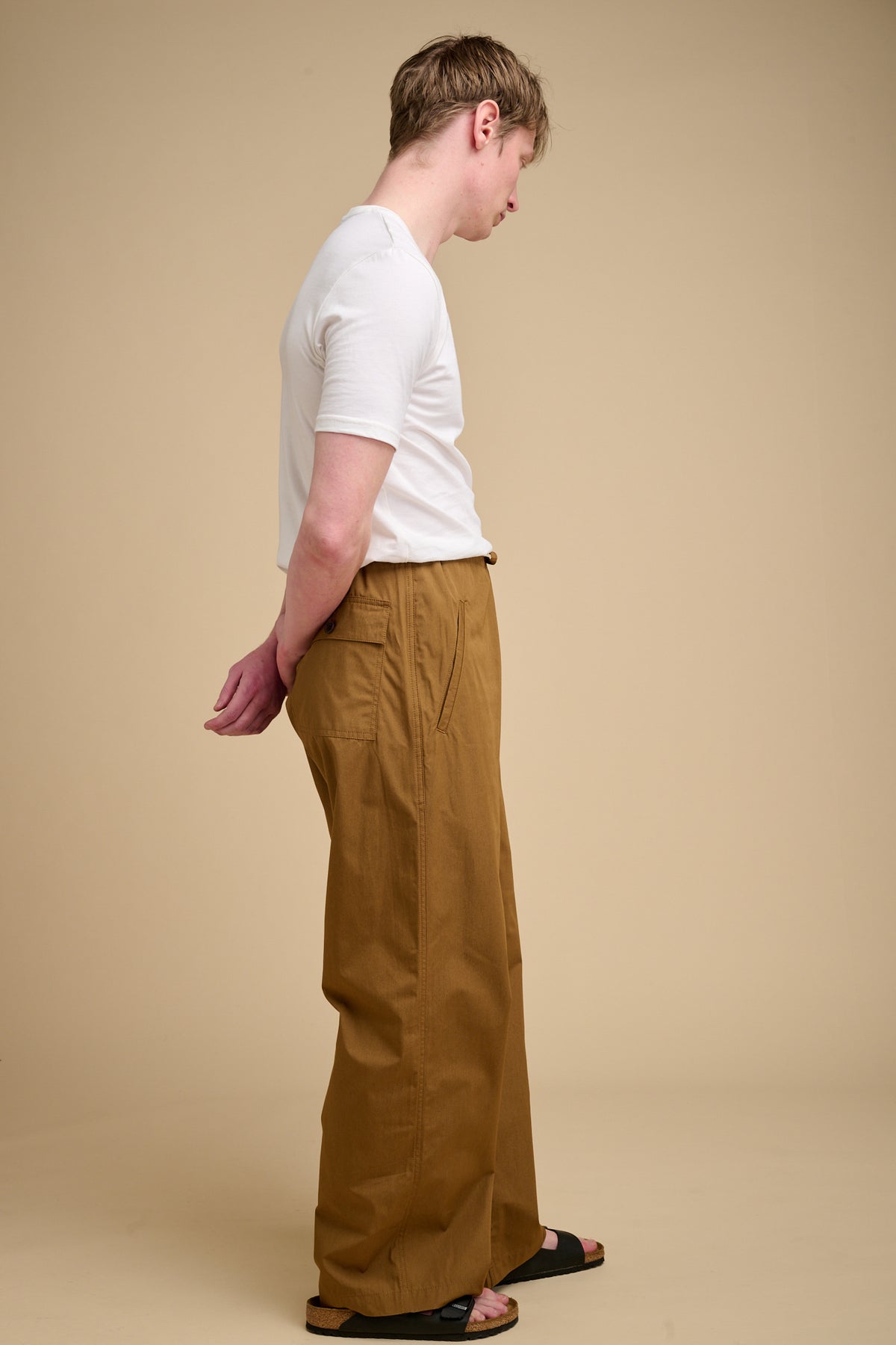 Man wearing tan wide leg trousers.