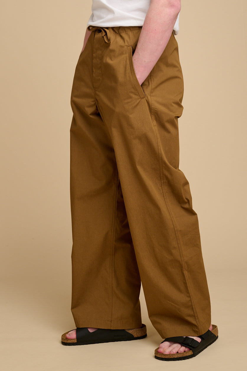 Man wearing tan wide leg trousers.