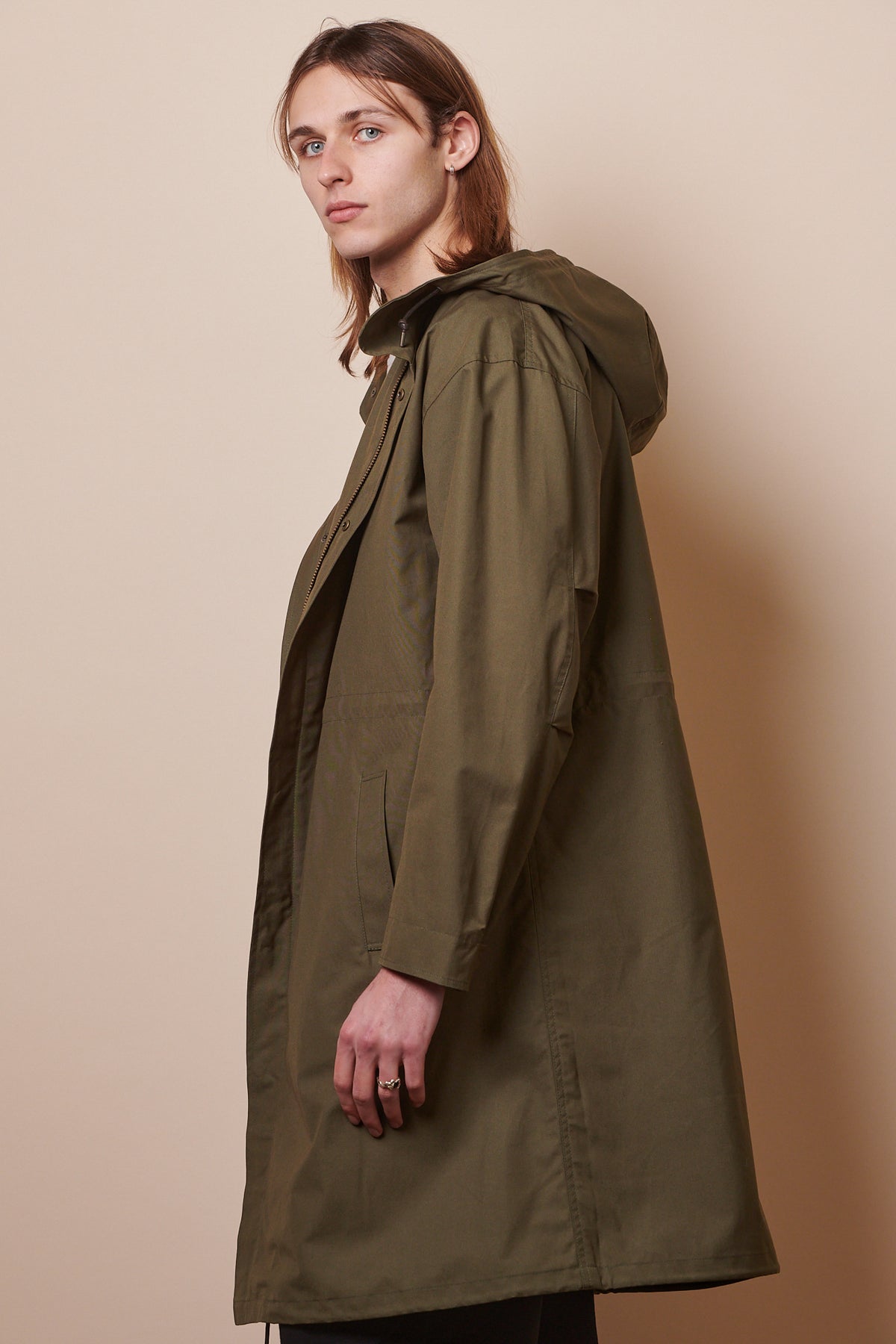 Side of male wearing parka in olive 