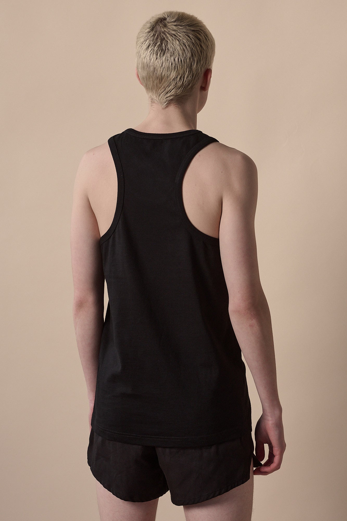 Back of male wearing men's racer back vest in black