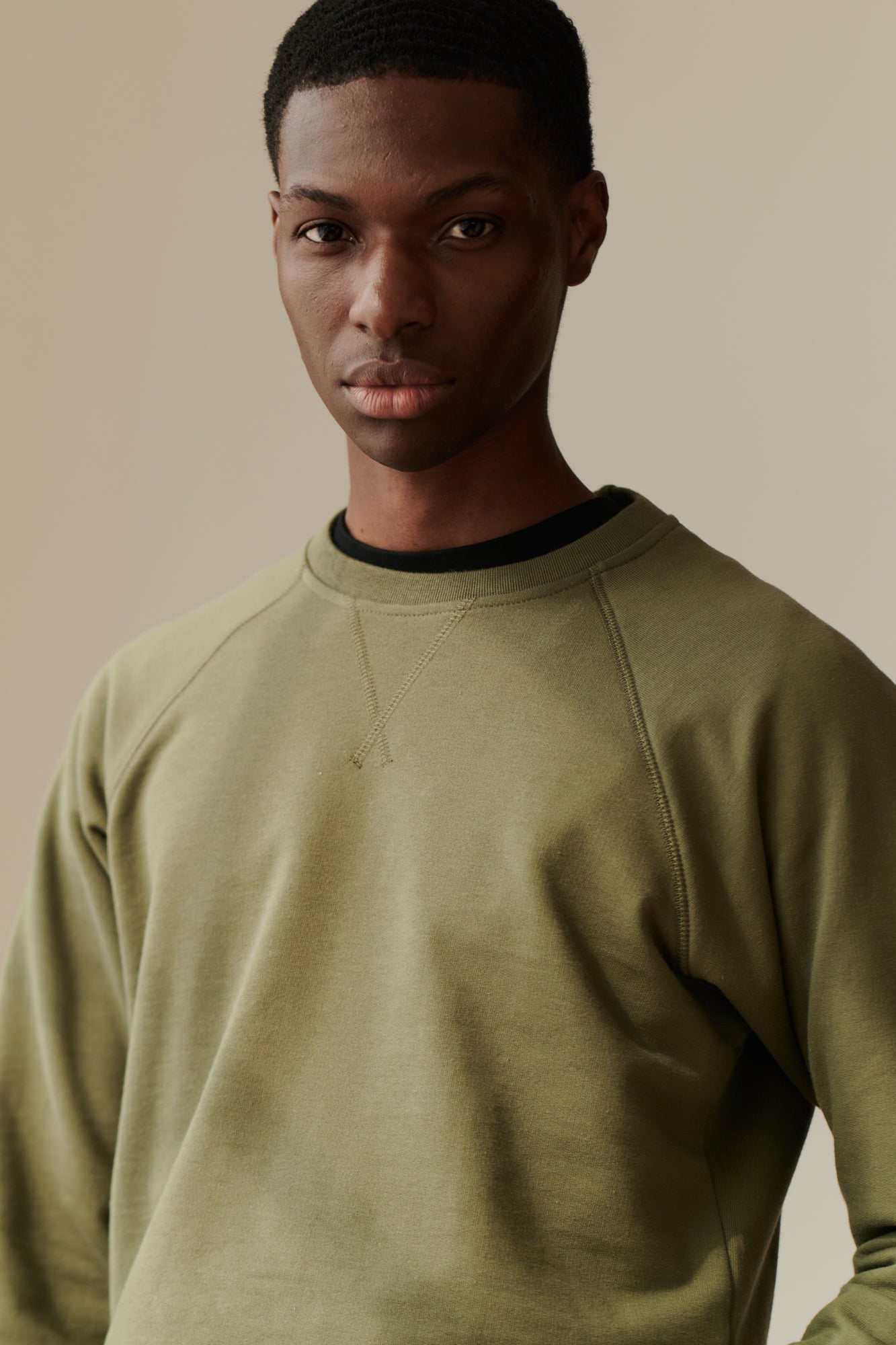 Front image of male wearing raglan sweatshirt in olive