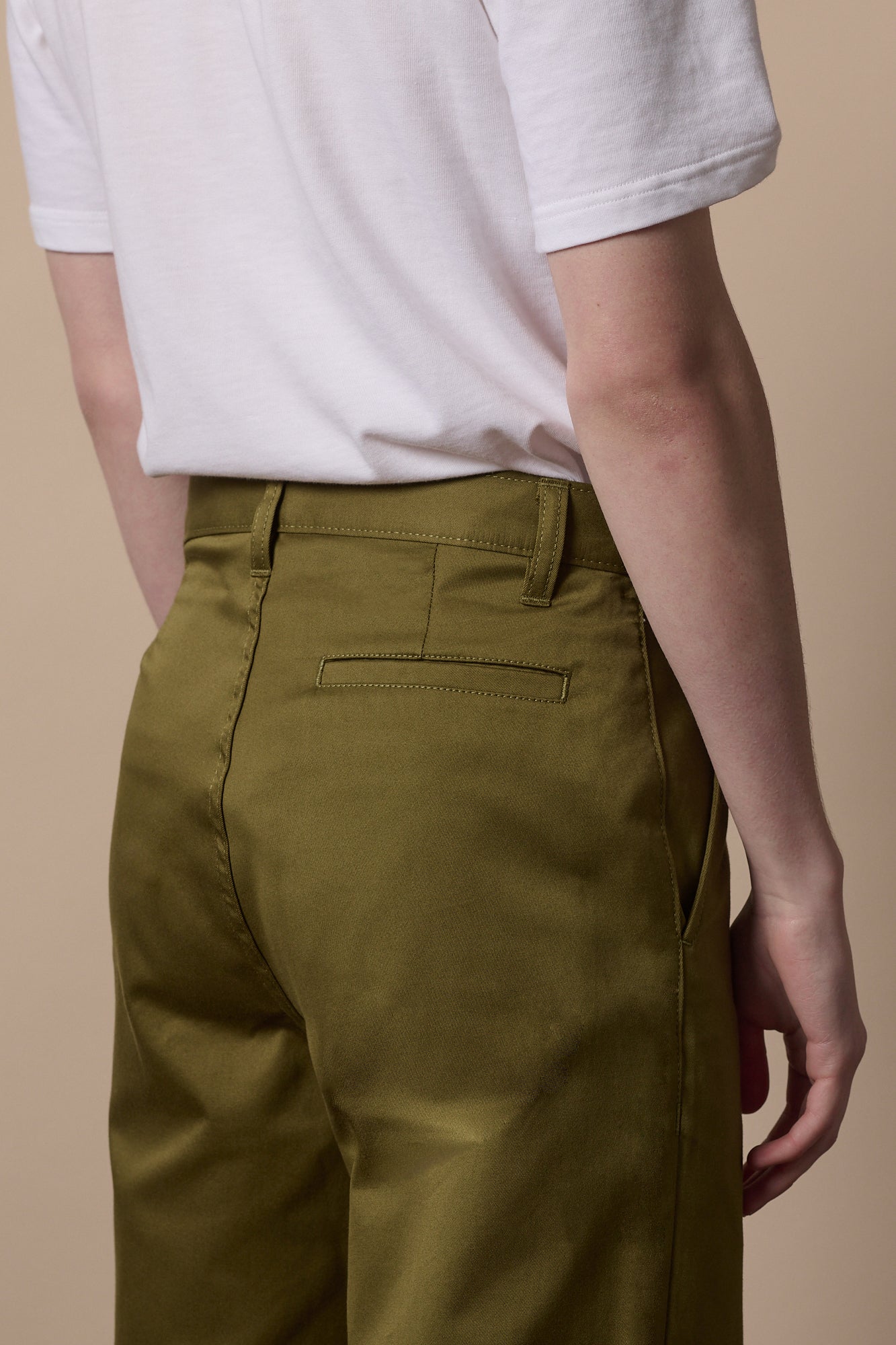 Full body image of white male wearing relaxed chino in moss paired with sweatshirt in stone
