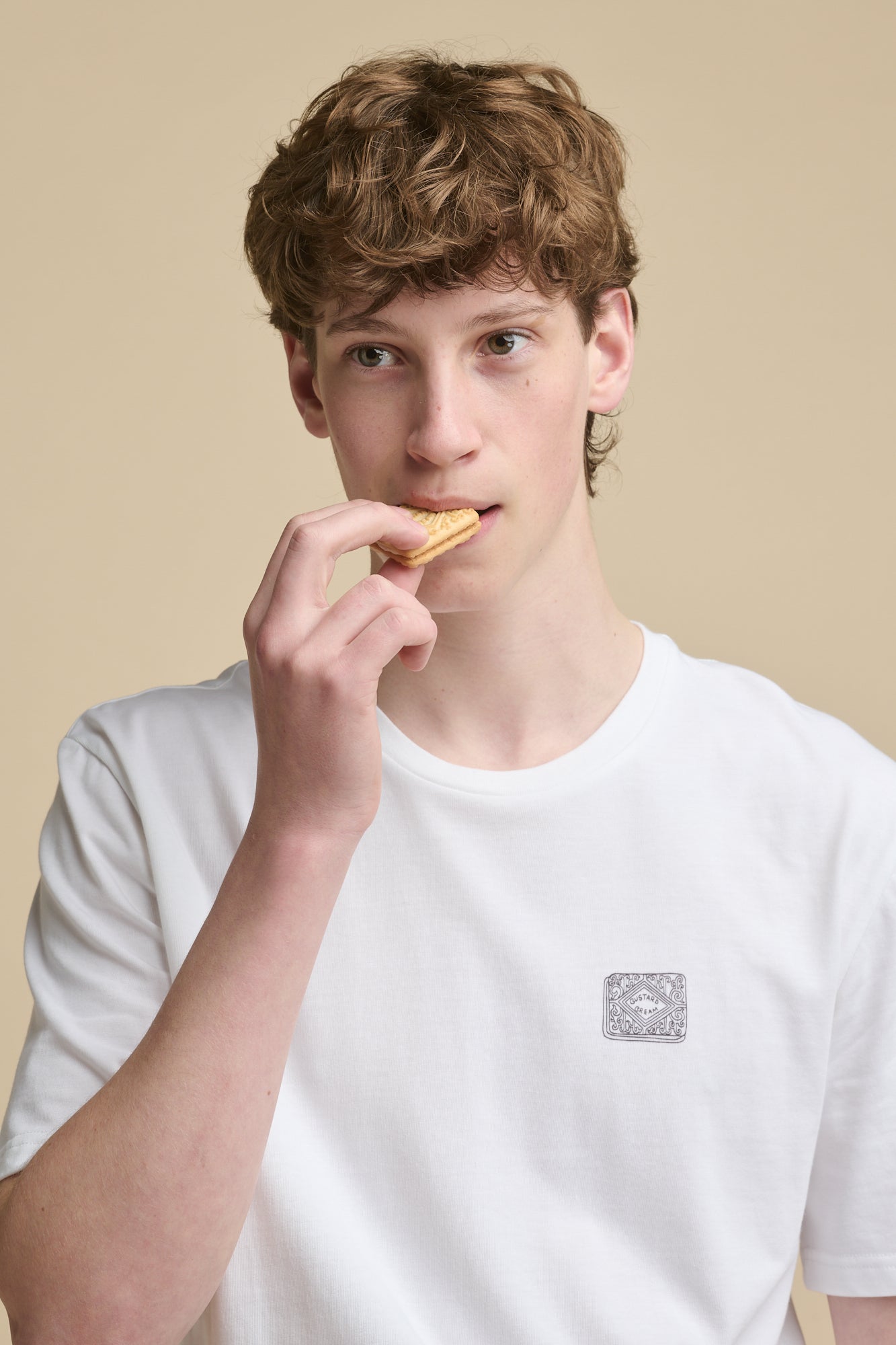 Thigh up image of male wearing short sleeve graphic t shirt with custard cream biscuit print 
