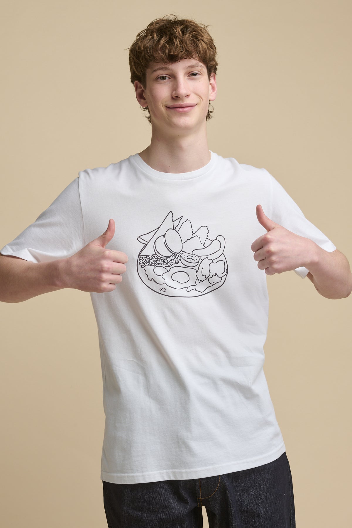 Thigh up front of smiley male with thumbs up, wearing short sleeve t shirt with full english print on the front 