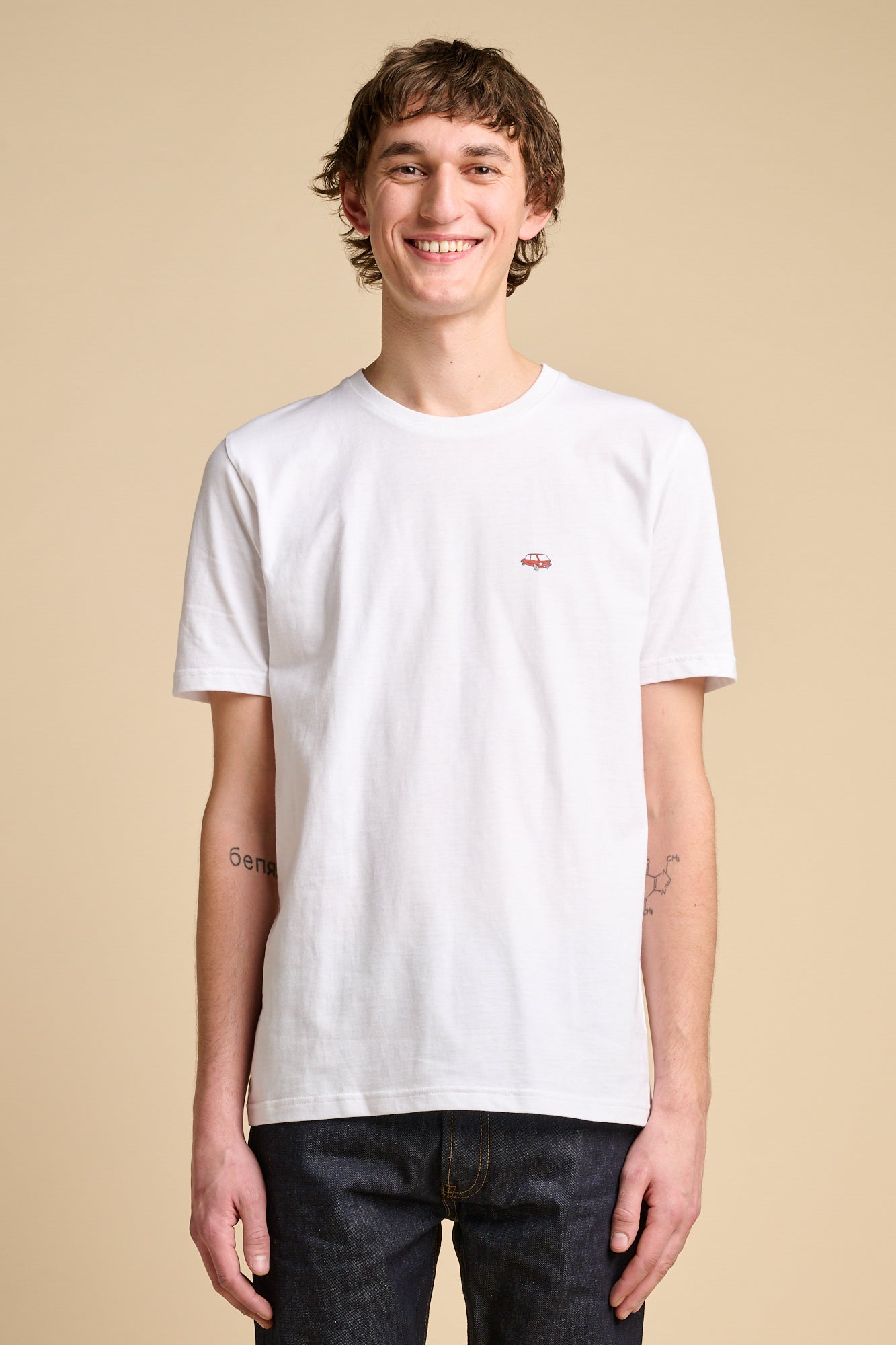 Smiling man wearing short sleeve white t shirt with small graphic print