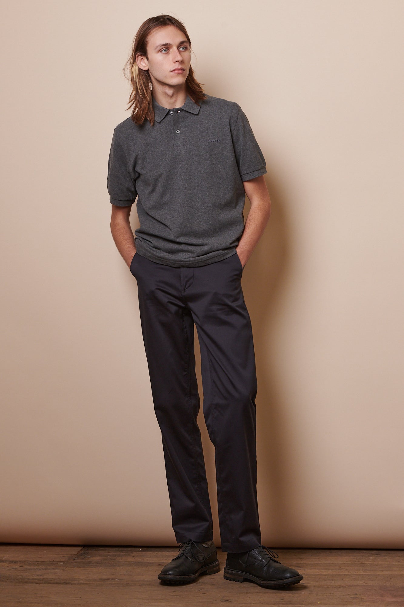 image showing male wearing short sleeve polo shirt in grey marl paired with navy chinos