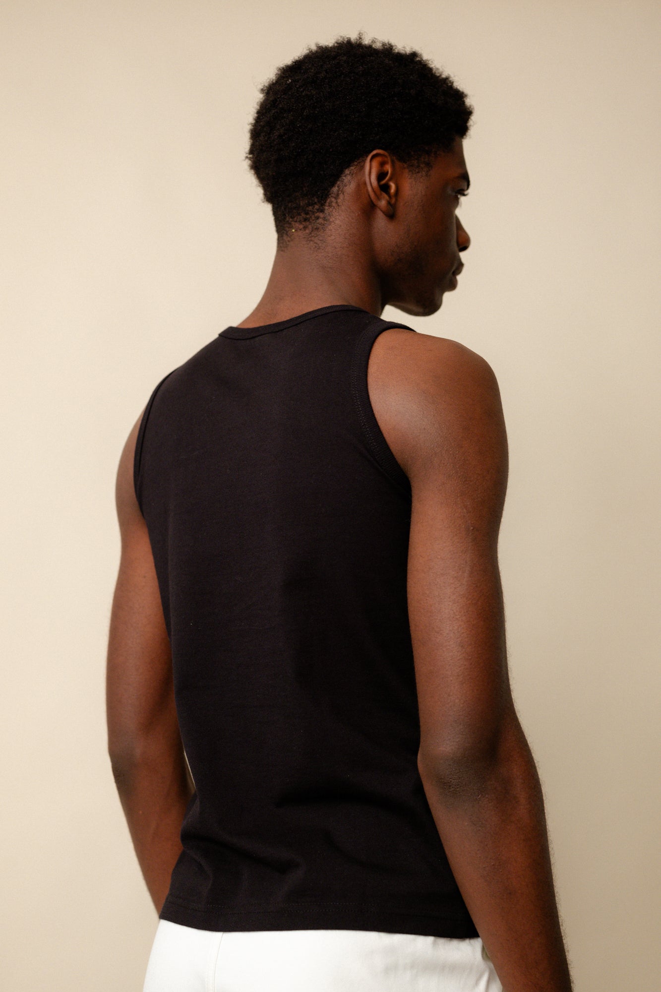 Black male wearing men's sleeveless t shirt plastic free in black