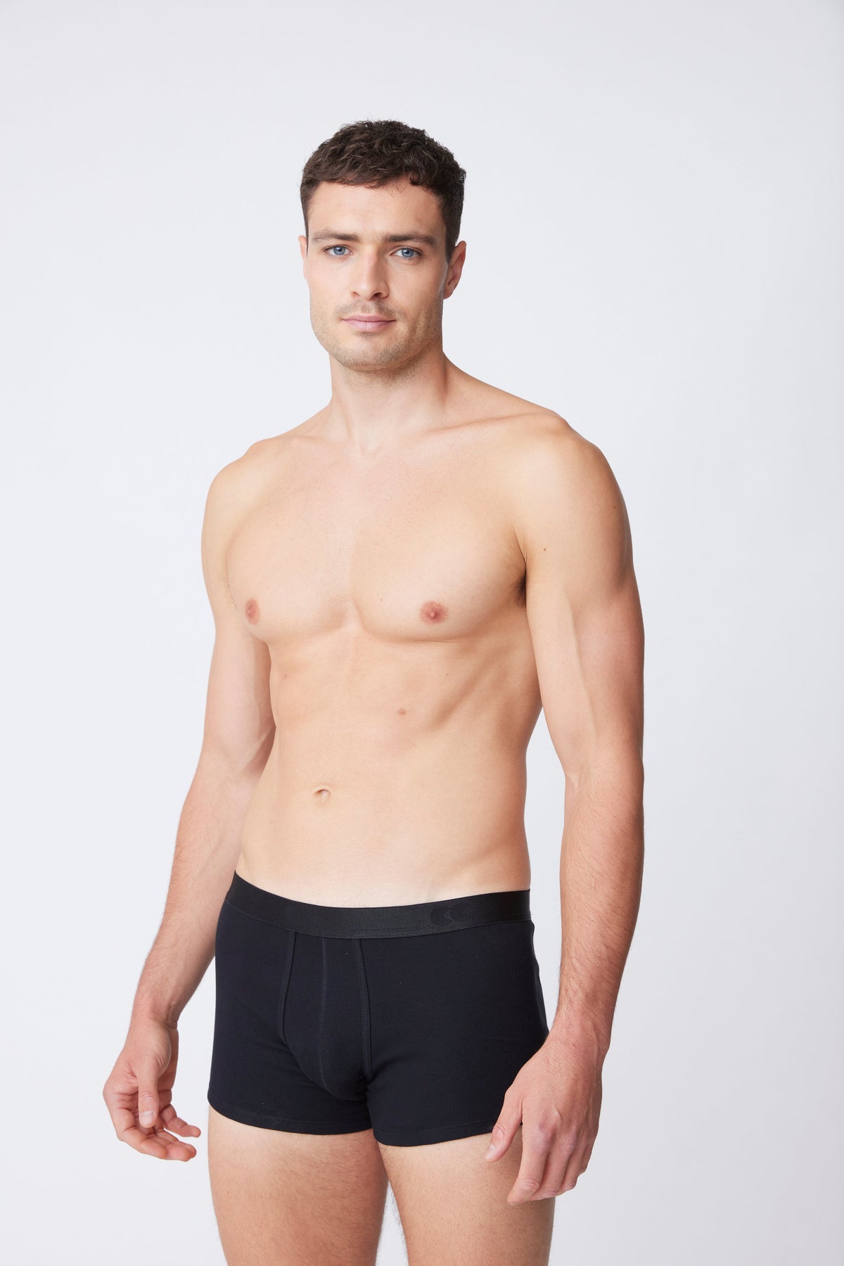 White male wearing black trunks 