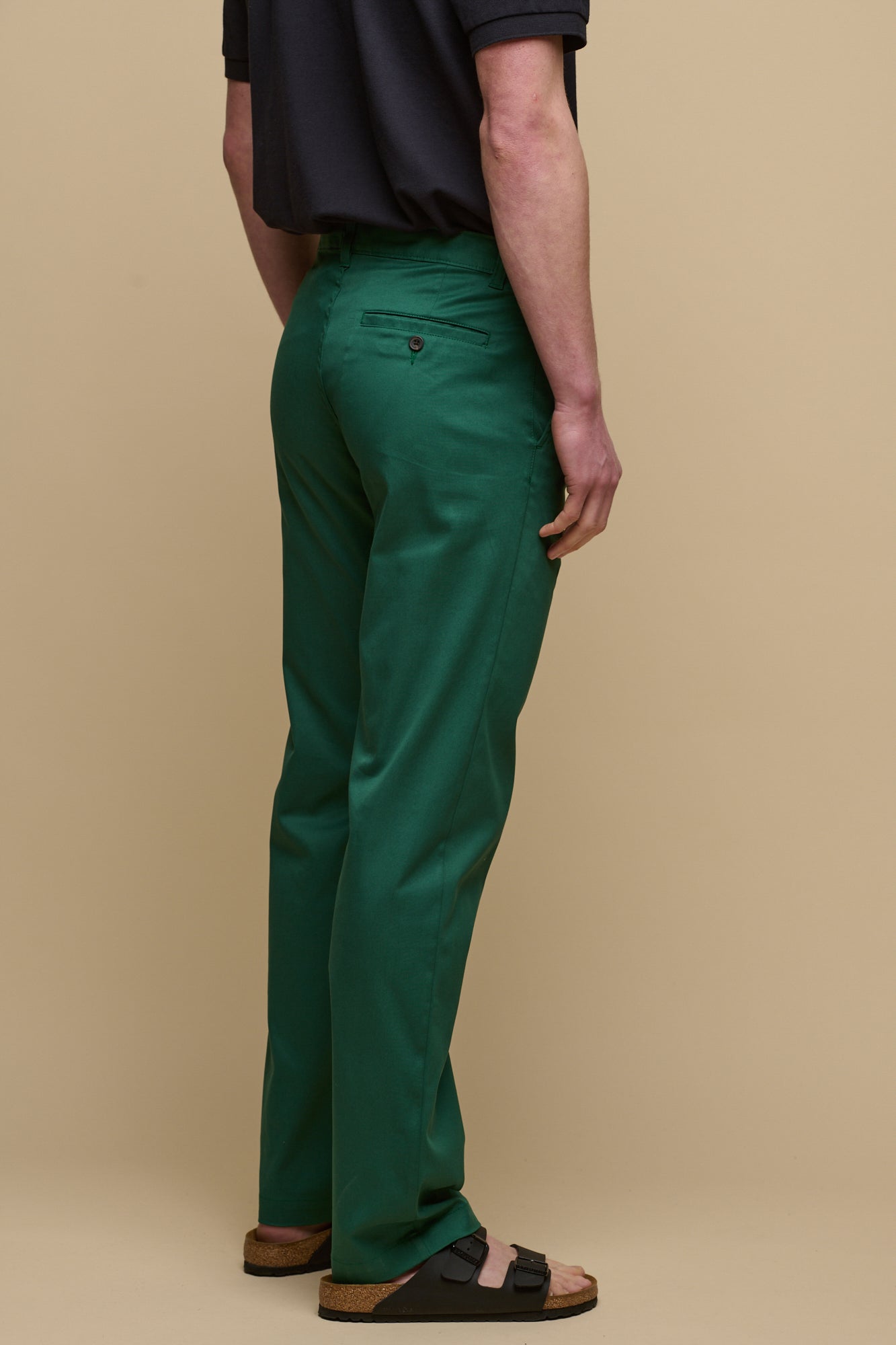 The back of male wearing slim stretch chino in bottle green with short sleeve polo shirt tucked in