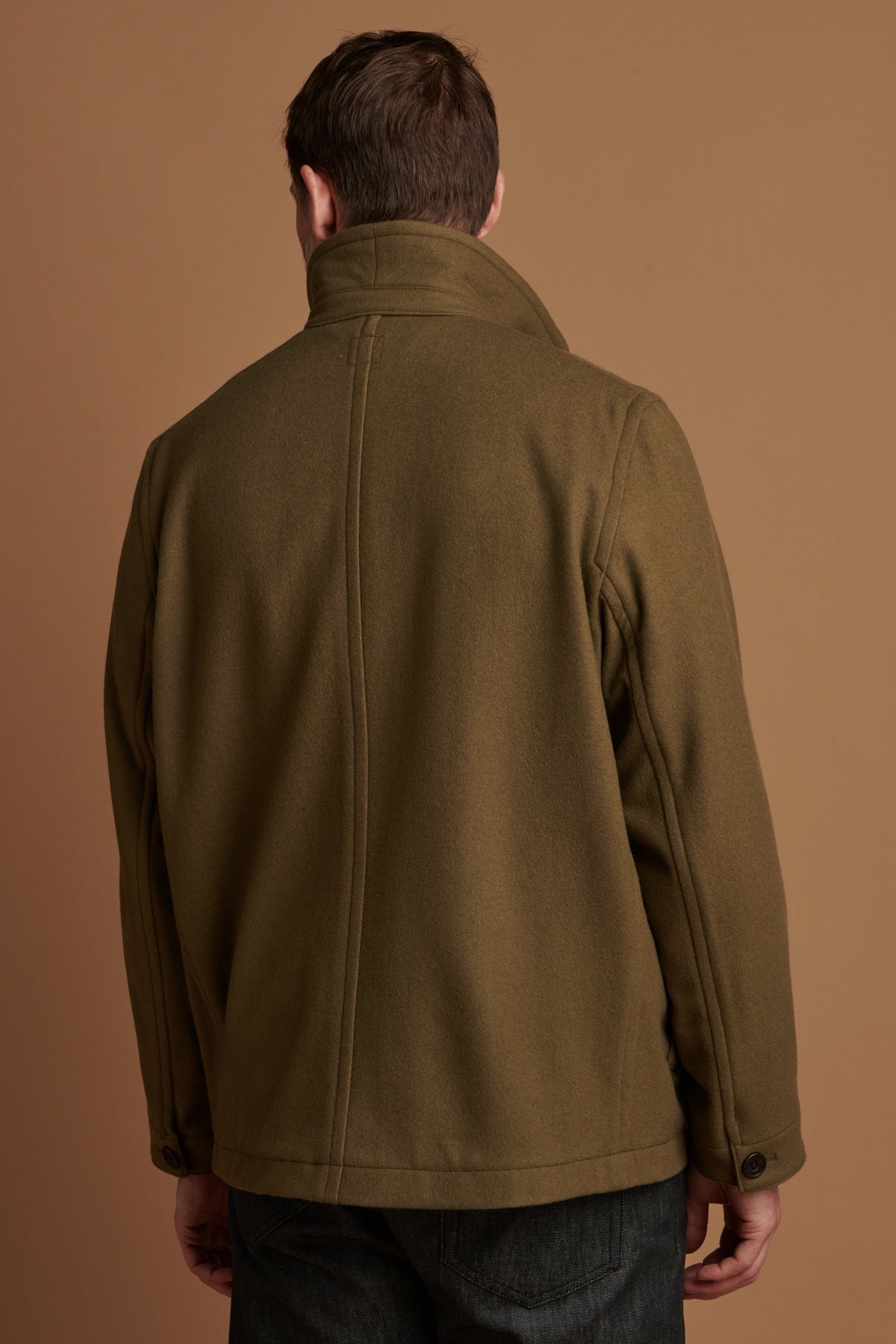 The back of Patrick Grant wearing Arthur wool chore jacket in olive with the collar up. 