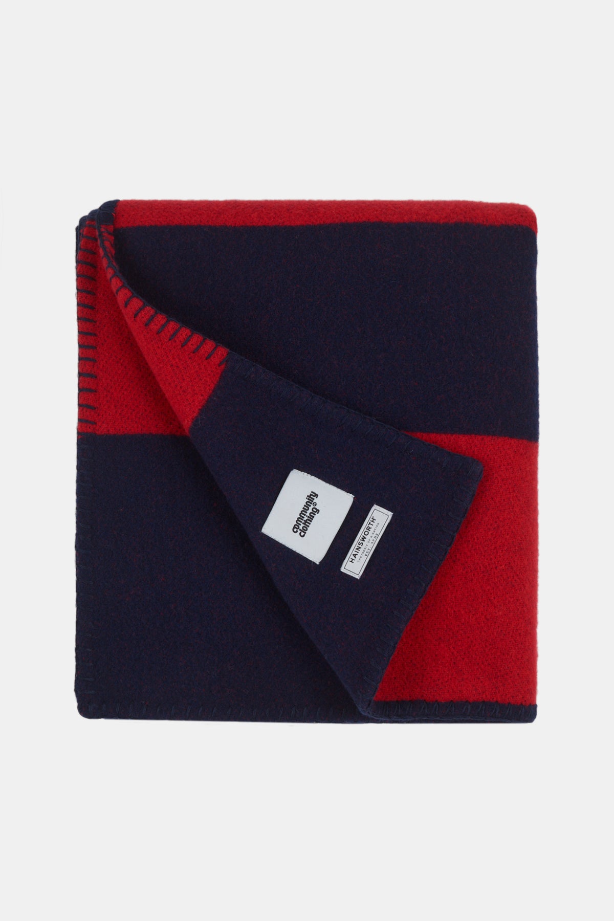 Flatlay image of navy red striped pure wool blanket showing Community Clothing and A W Hainsworth label