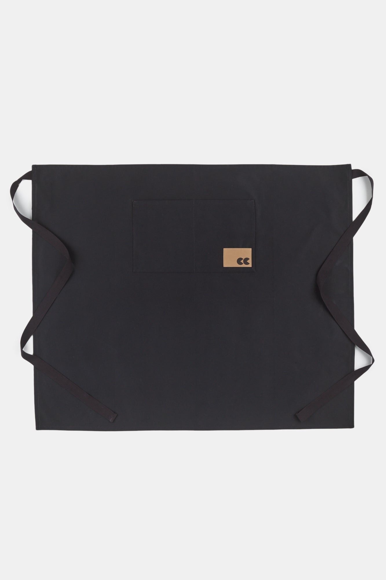 Flatlay image of unisex half apron in black with front pocket and CC logo patch